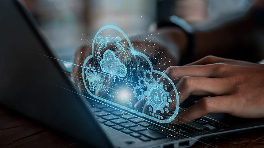 Amazon Web Services | Immagine di una persona al pc, si vede in sovrapposizione la nuvola che simboleggia il Cloud
